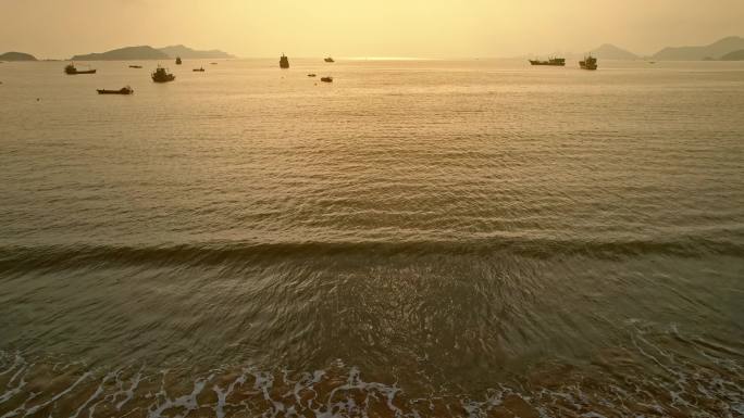 海上日出海浪沙滩渔船
