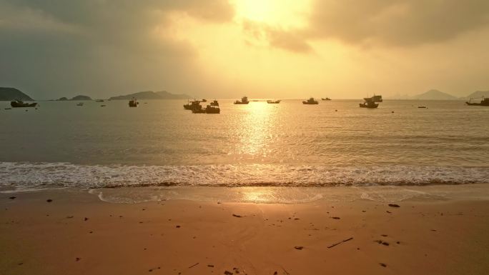 海上日出金色海面沙滩渔船