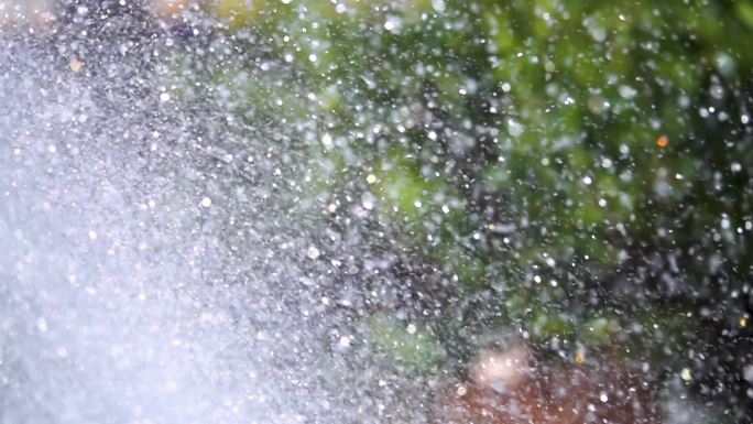 一个装饰喷泉洒水在慢动作特写，水粒子分散在不同的方向