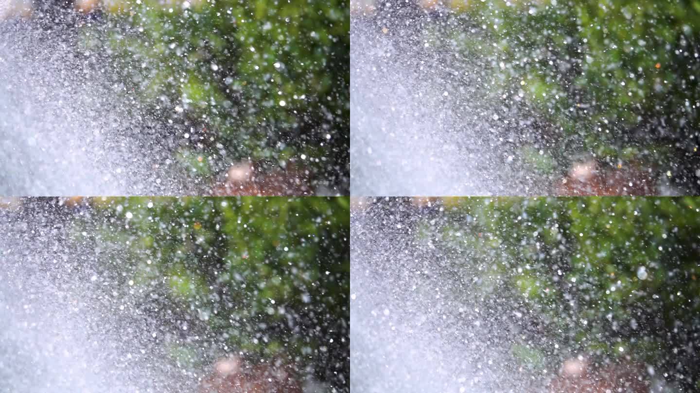 一个装饰喷泉洒水在慢动作特写，水粒子分散在不同的方向