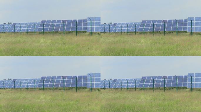 光伏电站，带有电池面板，在大风天对草场产生绿色能量。太阳能公园。来自发电和发电厂的光伏模块的生态电力