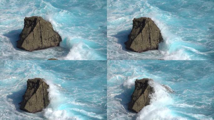 慢动作关闭: 湍流泡沫海浪打破尖锐的岩石礁。汹涌的桶波击中岸边飞溅浅滩。强大的冲浪打破撞击岩石喷洒水