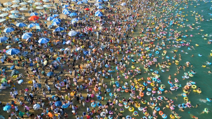 夏日阳光沙滩周末海边度假旅游游泳人群