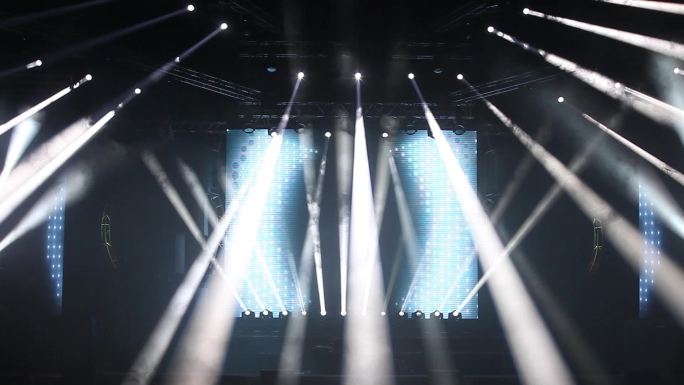 五颜六色明亮的舞台灯光在音乐会蓝色和白色的灯光聚光灯