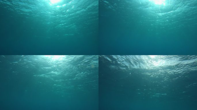 慢动作，水下，视点: 在溺水之前游到翡翠海洋的闪闪发光的表面。明亮的太阳光穿过闪烁在翡翠大海中的照相