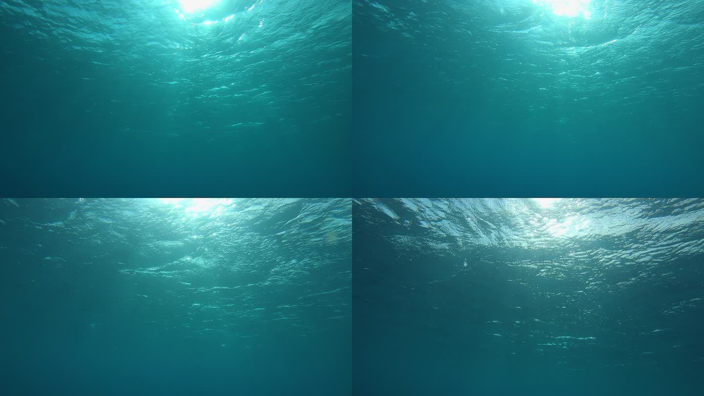 慢动作，水下，视点: 在溺水之前游到翡翠海洋的闪闪发光的表面。明亮的太阳光穿过闪烁在翡翠大海中的照相