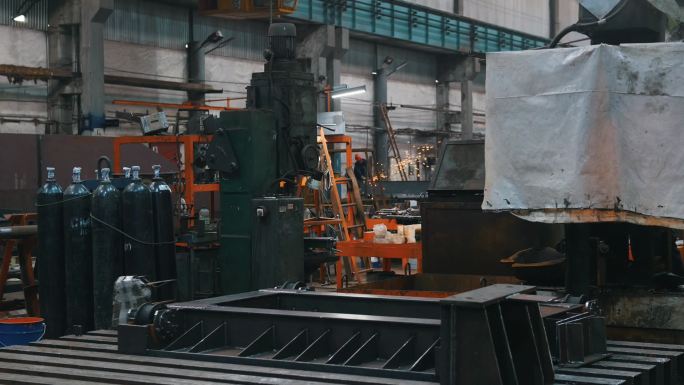 工厂 - 用于焊接和金属结构的气瓶 -在远处，一个人在陶瓷表面工作