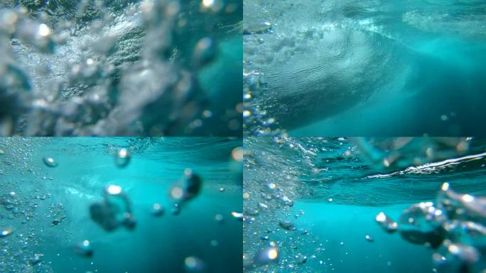 水下慢动作：水晶般清澈的桶波在深海中冲破相机。相机从富埃特文图拉阳光明媚的海滩下降到深晶莹的海水下巨