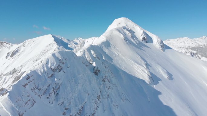 空中: 在风景如画的阳光明媚的阿尔卑斯山拍摄雄伟的雪山山脊的电影。沿着令人叹为观止的山脉飞行, 被刚