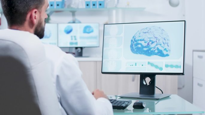 医生在显示器上观察3D脑部扫描