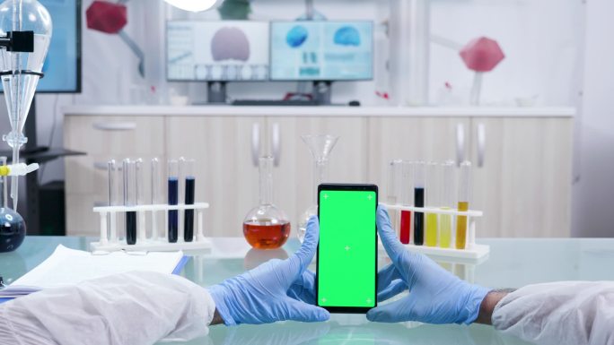拿着绿屏智能手机的科学家的视点镜头