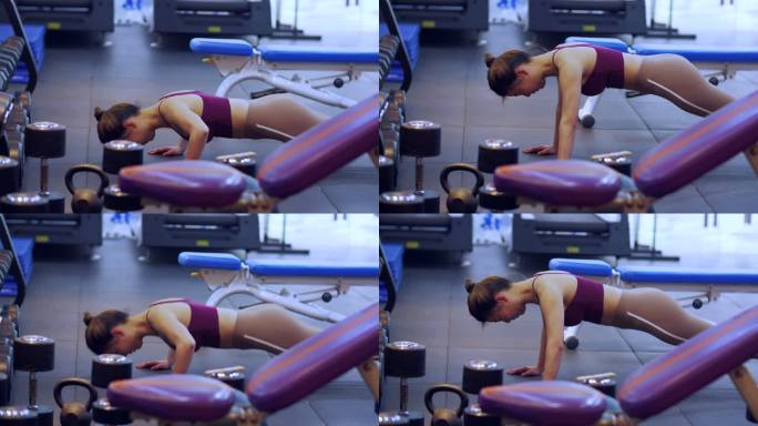 健康美女健身房锻炼身体做俯卧撑