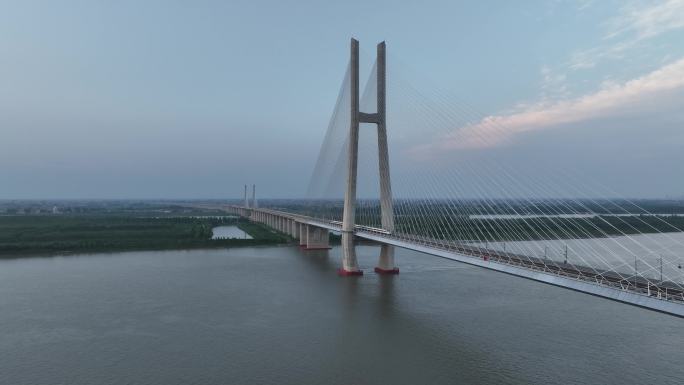 黄昏航拍高速列车通过鳊鱼洲长江大桥