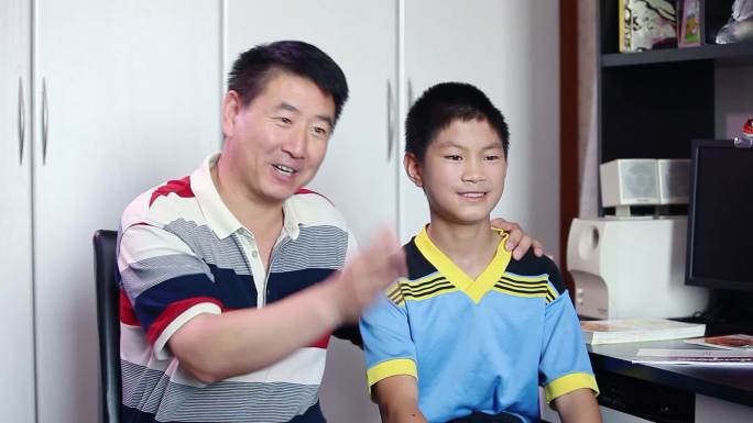 父亲陪伴儿子出镜接受采访阐述着儿子的优秀