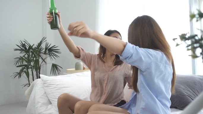 慢动作-小组的朋友亚洲妇女狂热的球迷观看足球比赛在电视上庆祝的目标在沙发上尖叫兴奋和狂喜在疯狂快乐的