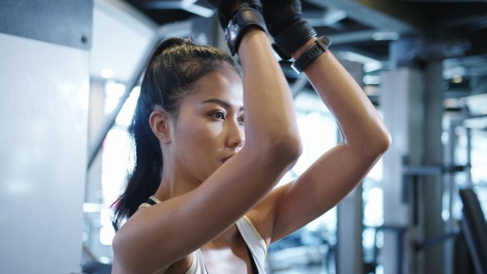 年轻的亚洲女士在健身课上做运动机械电缆交叉体脂燃烧锻炼。运动员六包，女运动员娱乐活动，功能性训练，健