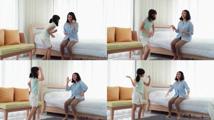 妈妈和女儿在卧室里欢快地跳舞。