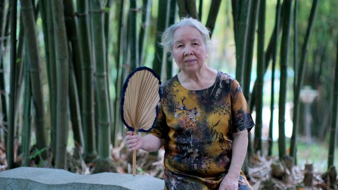 炎热夏天老人老奶奶竹林里乘凉摇扇子