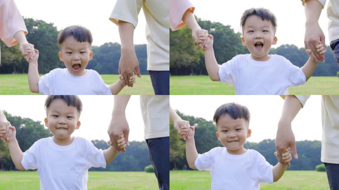 快乐的小男孩和他的父母在公园里奔跑