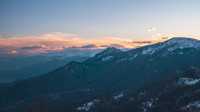 时光流逝:夕阳西下的阿尔卑斯山、独特的风景全景、高山山谷移动的云彩、冬季。