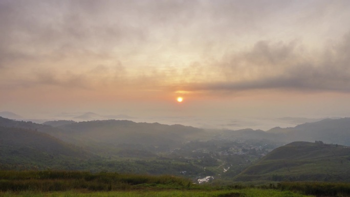 美丽的金色日出，快速滚动的云彩飘过村庄。在拉瑙、沙巴、婆罗洲拍摄。时差运动盘右边