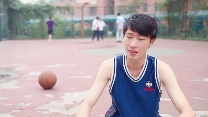 一男子坐在篮球场上接受采访诉说着亲身经历