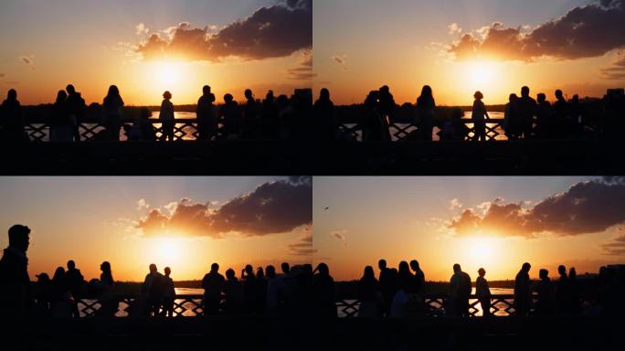 桥上看日落的人群剪影