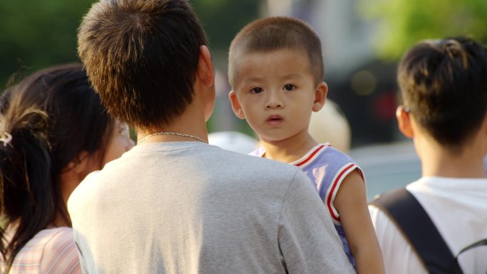 大人抱小孩 马路边 夏天 等红绿灯 炎热