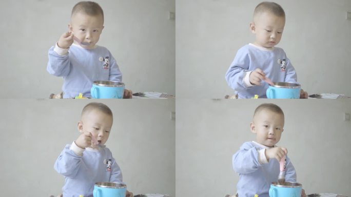 使用勺子学吃饭的小男孩幼童