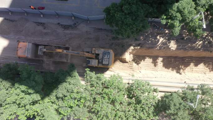 俯拍挖掘机在城市开挖管沟