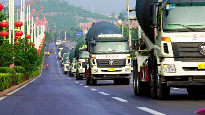 排队行驶在城市道路上的水泥罐车