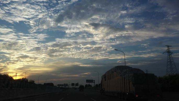 车辆行驶在高速公路上满天云彩与霞光