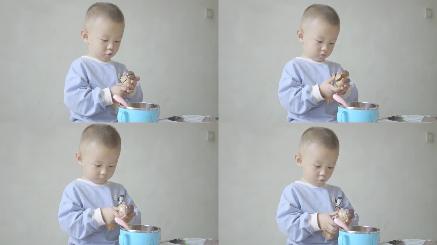 使用勺子学吃饭的小男孩幼童