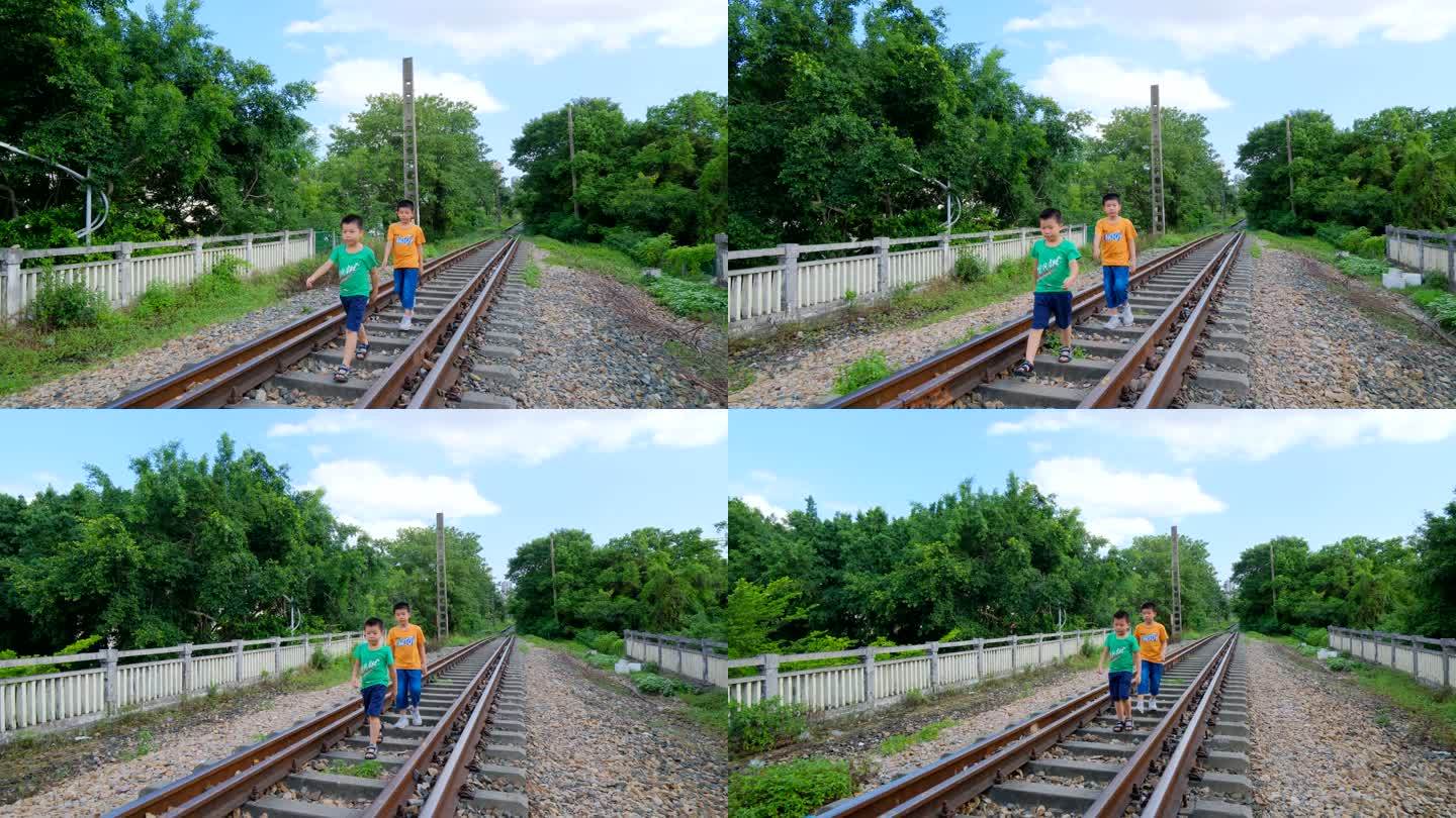 两个小孩走在铁路上玩耍
