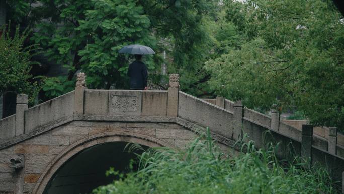 慢镜头中式雨景男子桥上雨中撑伞独行