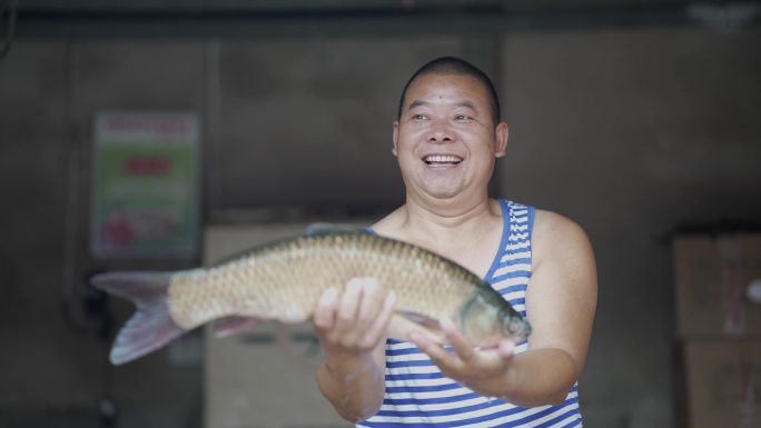 渔民钓友手捧一条大鱼开心的笑
