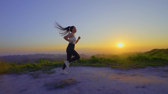 唯美女孩日落时分山顶跑步清晨锻炼有氧运动