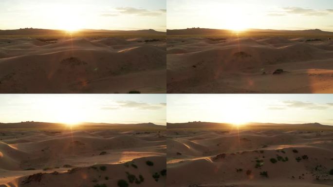落日笼罩在沙漠的沙丘上 