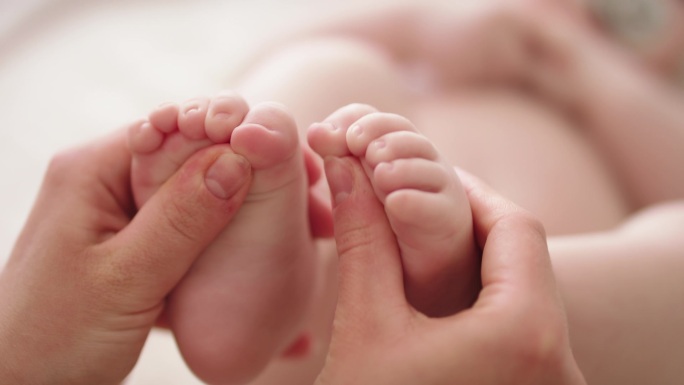 妈妈在玩婴孩的脚幼儿发展概念的伸展和练习