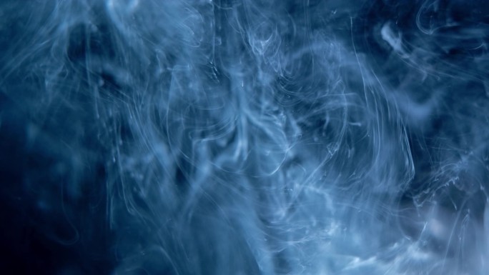 烟的抽象。云彩蓝光下的黑色背景。烟熏效果.