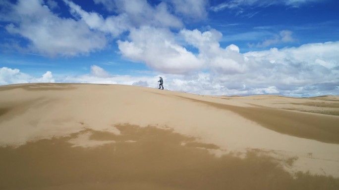 沿着沙丘边走的游客