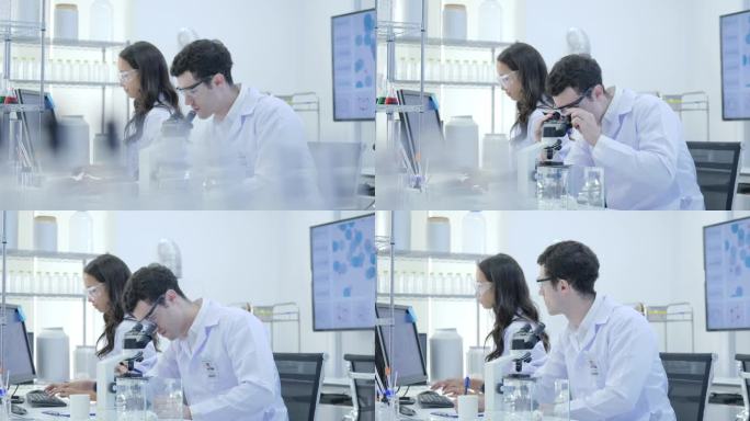 医学研究专家团队在现代实验室与科学家进行实验, 在计算机上工作, 在显微镜下观察物质
