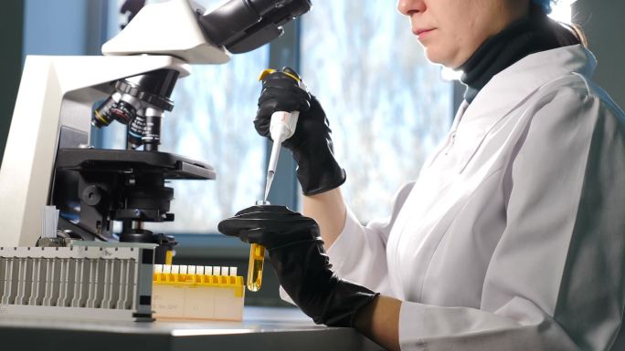 在与试管合作的过程中，用微型管道拍摄《手套》研究人员的女性手的特写镜头。创新药物实验室配备现代遗传学