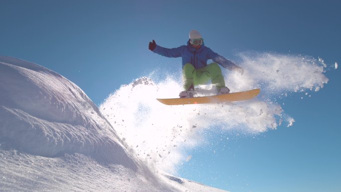 慢动作：鼓励滑雪者在新雪中跳跃，在阳光下喷射雪花