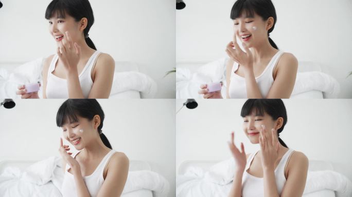 漂亮的年轻亚洲女人拿着药筒在脸上涂上乳霜或润肤乳液，漂亮的亚洲女孩用化妆品触摸皮肤，护肤理念.
