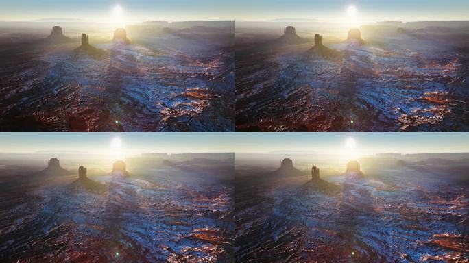 太阳直接照进相机，在无尽的沙漠纪念碑山谷上方到达地平线