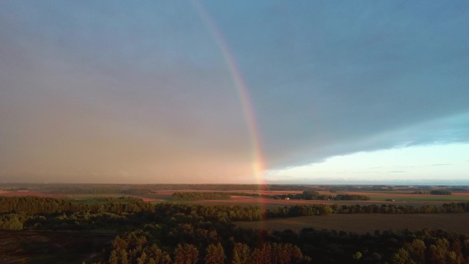 双彩虹覆盖森林和麦田。深雷雨乌云，彩虹覆盖乡郊公路景观。Areal Dron射击