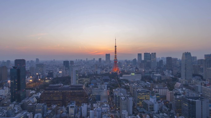 日落时分，东京天际线与东京塔楼相望，夜以继日。空中风景。往下倾斜