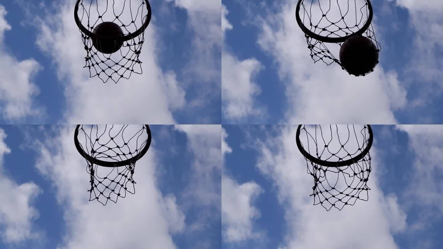 球缓缓地飘进篮筐和网眼背景美丽的云彩天空的底部视图.