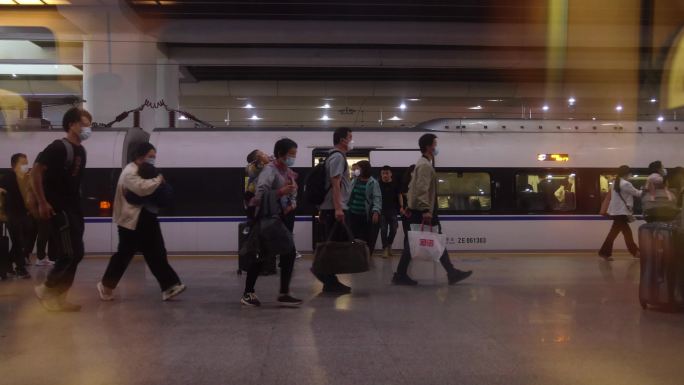 高铁站台上的旅客拖着行李箱